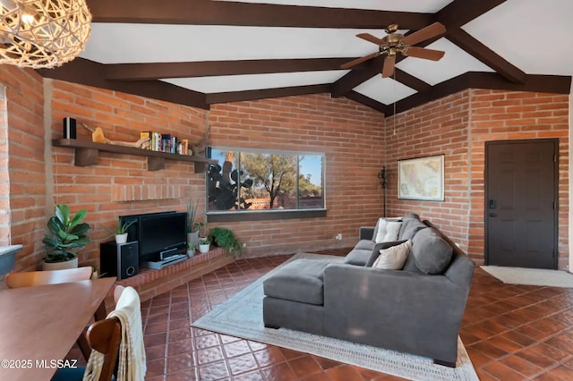 living room with brick wall, a brick fireplace, vaulted ceiling with beams, and ceiling fan