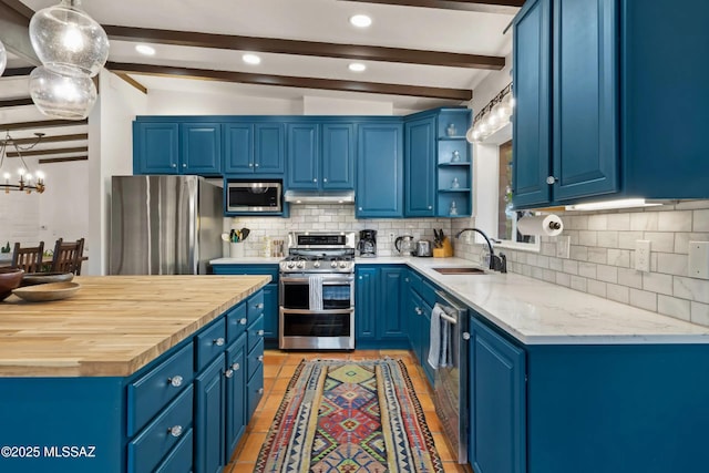 kitchen featuring blue cabinets, appliances with stainless steel finishes, sink, and lofted ceiling with beams