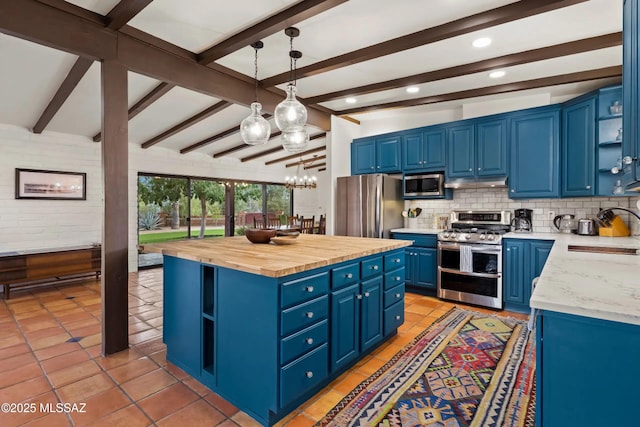 kitchen with pendant lighting, wood counters, sink, stainless steel appliances, and blue cabinetry