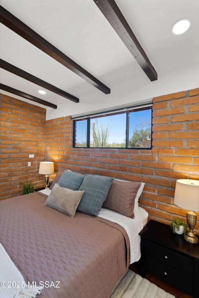 bedroom featuring beam ceiling and brick wall