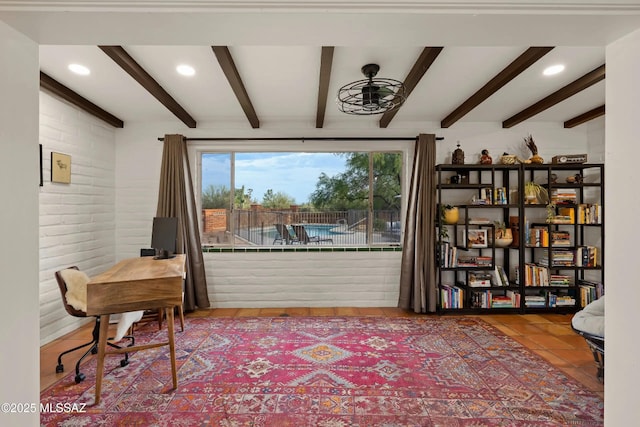 interior space with beamed ceiling, ceiling fan, and brick wall