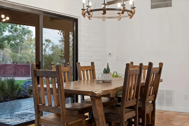 tiled dining room featuring a chandelier