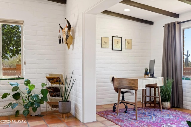 interior space featuring brick wall, light tile patterned floors, and beam ceiling