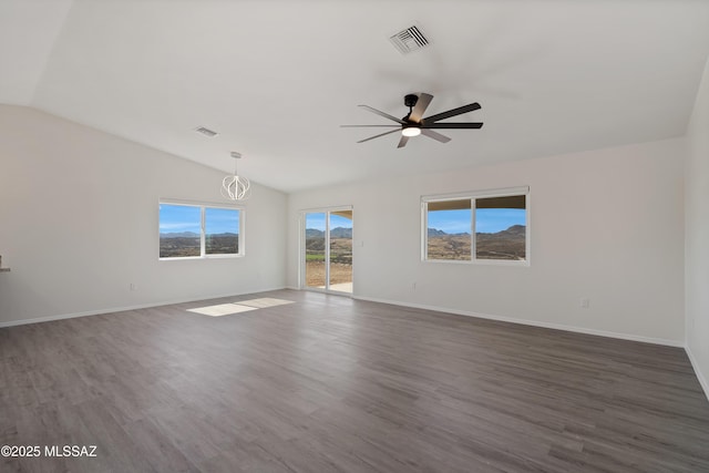 spare room with lofted ceiling, dark wood-type flooring, and ceiling fan with notable chandelier