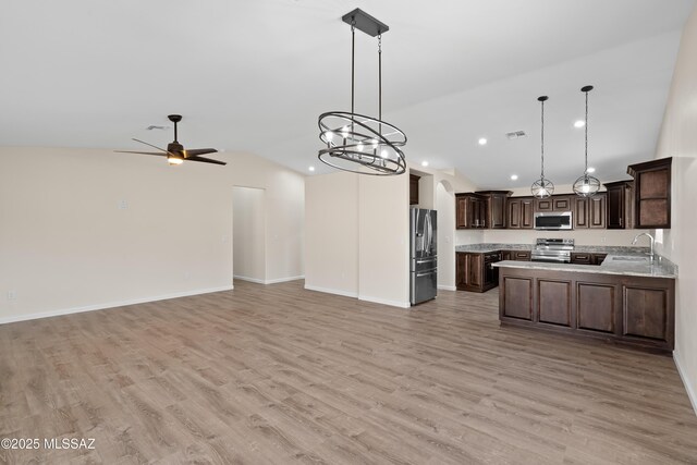 kitchen with pendant lighting, stainless steel appliances, sink, kitchen peninsula, and light hardwood / wood-style flooring