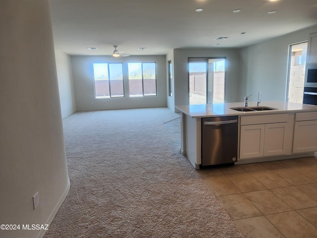 kitchen with light carpet, dishwasher, ceiling fan, sink, and white cabinets