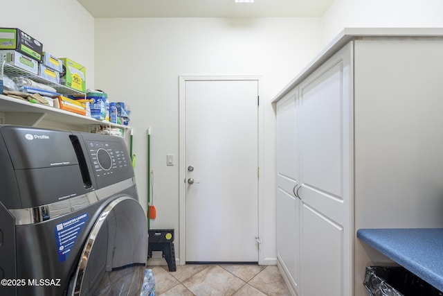 clothes washing area with light tile patterned floors and washer / clothes dryer