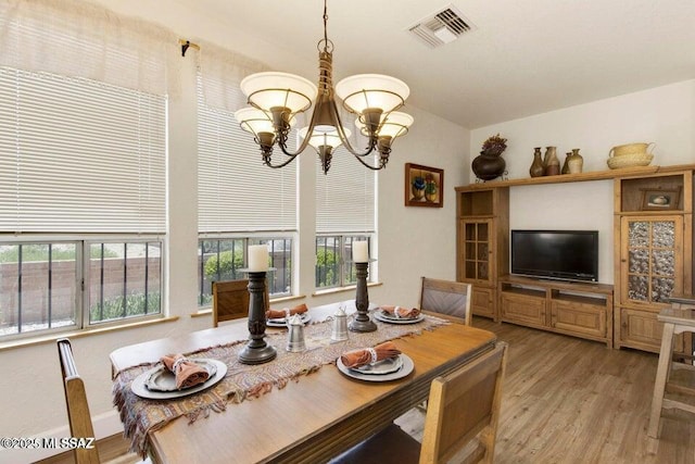 dining space featuring an inviting chandelier and light wood-type flooring