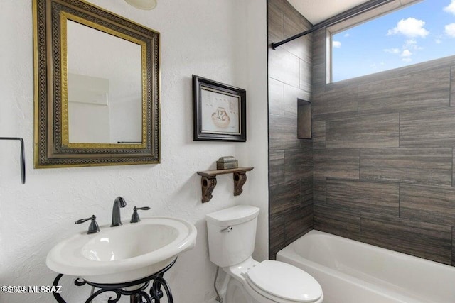 full bathroom featuring toilet, tiled shower / bath combo, and sink