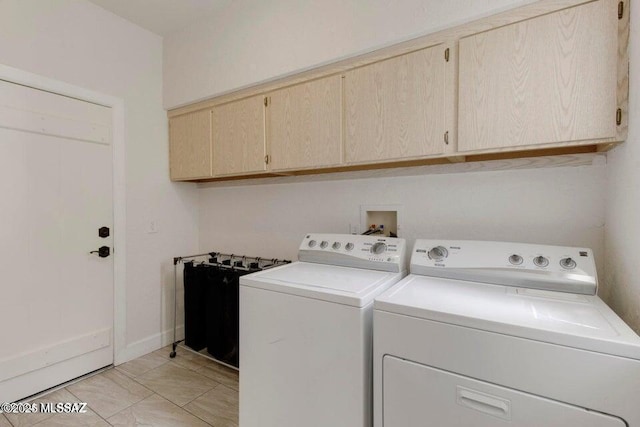 clothes washing area featuring cabinets, light tile patterned floors, and independent washer and dryer