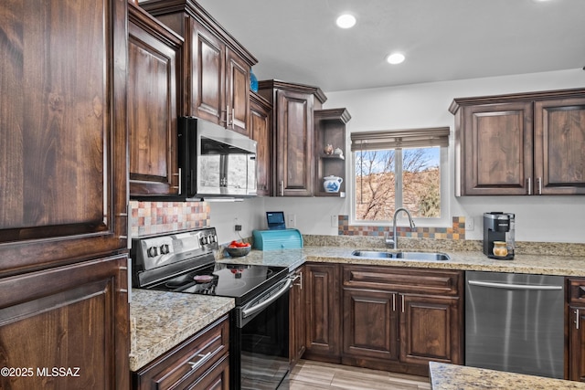 kitchen featuring dark brown cabinetry, lofted ceiling, stainless steel appliances, sink, and hanging light fixtures