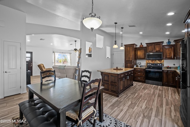 kitchen featuring sink, dark brown cabinetry, light stone counters, and appliances with stainless steel finishes