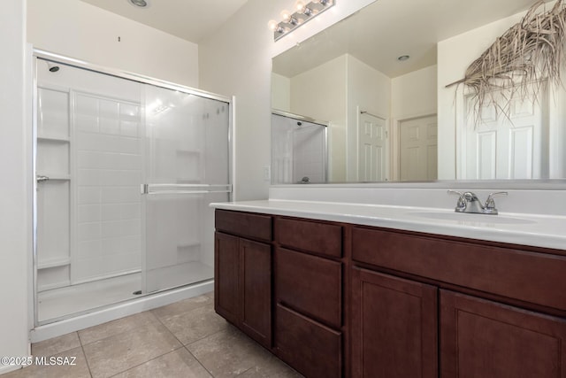 bathroom featuring tile patterned flooring, walk in shower, and vanity