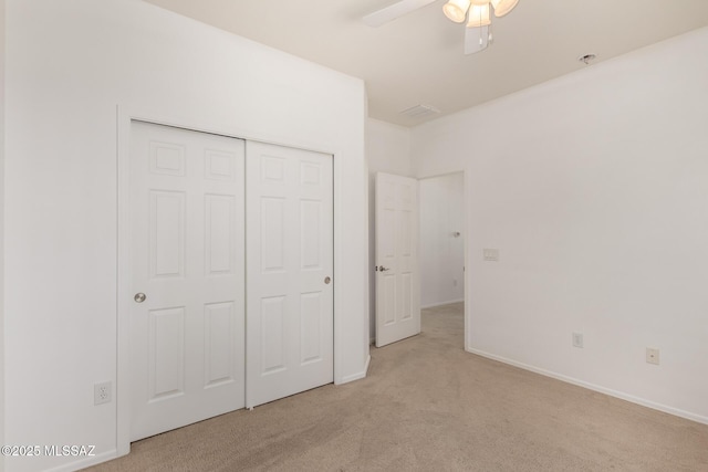 unfurnished bedroom featuring a closet, ceiling fan, and light carpet