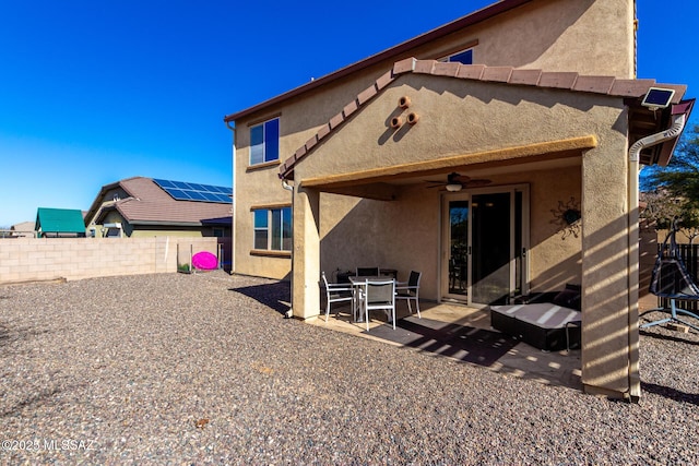 rear view of house featuring ceiling fan and a patio area