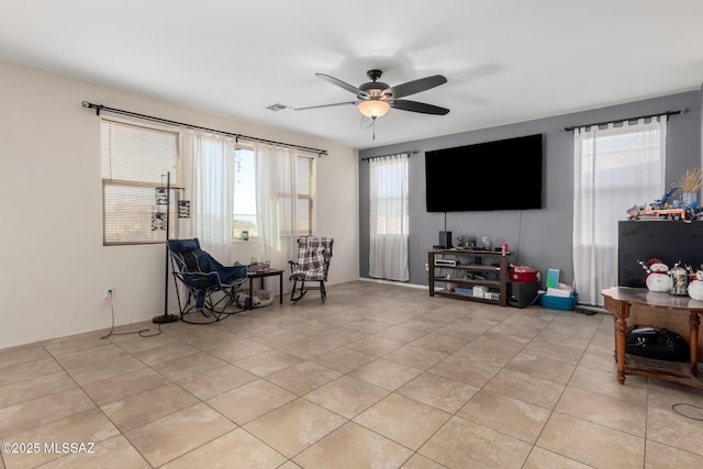 living area with ceiling fan and light tile patterned floors