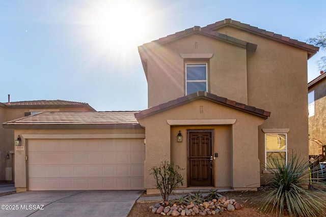 view of front facade featuring stucco siding, driveway, an attached garage, and a tiled roof