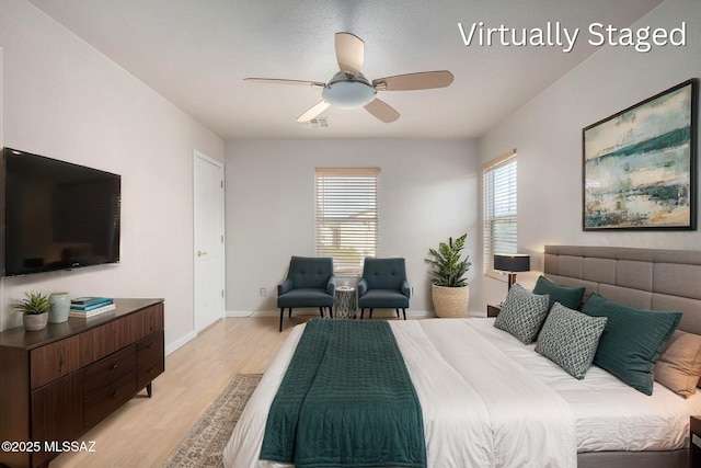 bedroom featuring light wood-style flooring, a ceiling fan, and baseboards