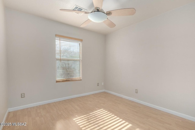 spare room with visible vents, baseboards, wood finished floors, and a ceiling fan