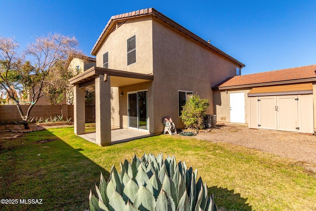 back of house with stucco siding, a lawn, fence, cooling unit, and a patio area