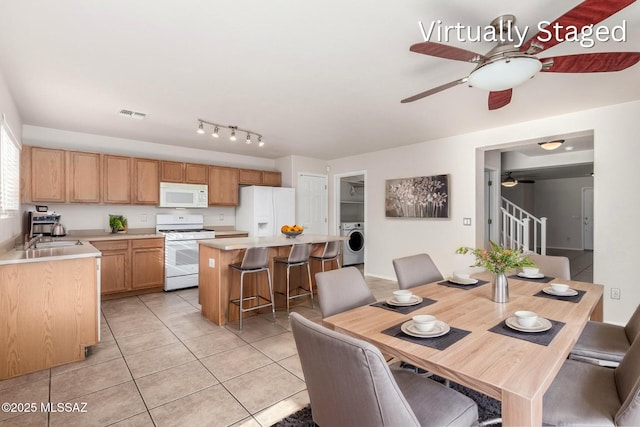 dining area featuring visible vents, a ceiling fan, washer / clothes dryer, light tile patterned floors, and stairs