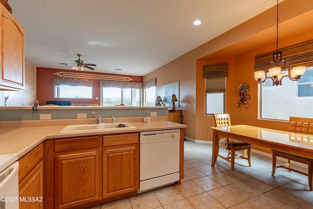 kitchen featuring pendant lighting, sink, light tile patterned floors, white dishwasher, and ceiling fan with notable chandelier