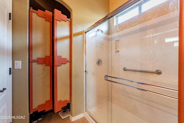 bathroom featuring a shower with shower door