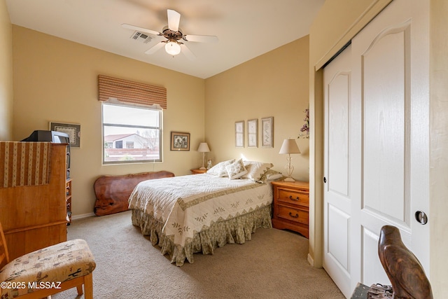 bedroom featuring light carpet, ceiling fan, and a closet