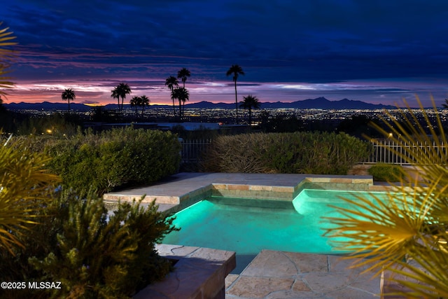 pool at dusk featuring a mountain view