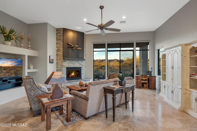 tiled living room featuring built in shelves, a fireplace, and ceiling fan