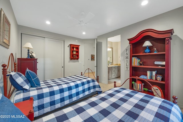 bedroom with ceiling fan, a closet, ensuite bathroom, and light carpet