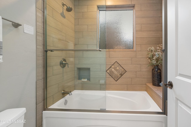 bathroom featuring combined bath / shower with glass door and toilet