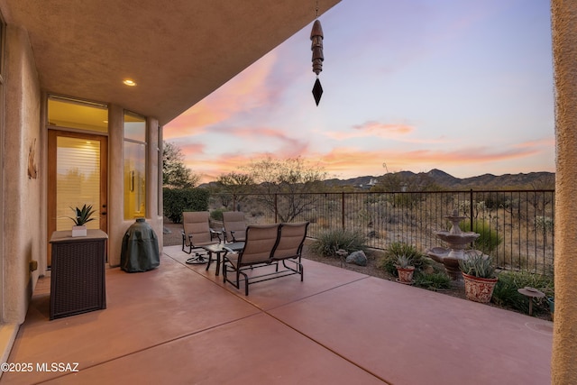 patio terrace at dusk featuring a mountain view