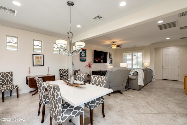 dining area featuring ceiling fan with notable chandelier