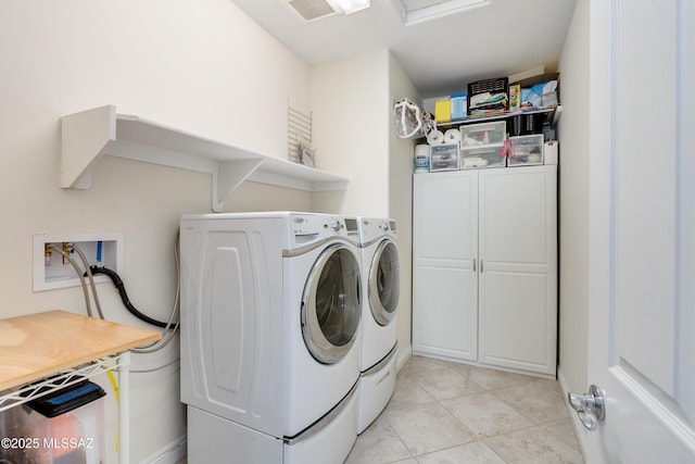 clothes washing area featuring light tile patterned flooring and separate washer and dryer