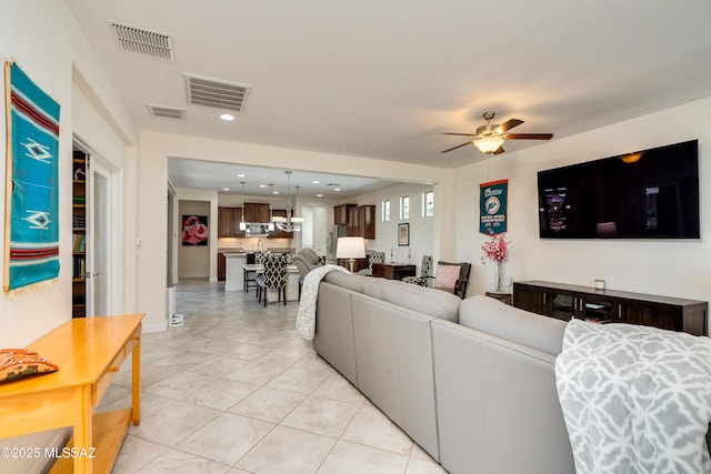 tiled living room with ceiling fan