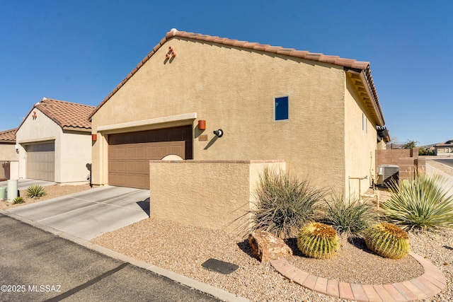 view of front of property featuring a garage and central AC