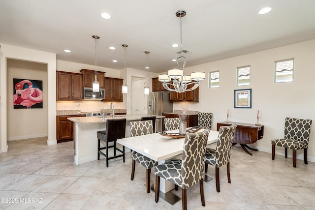 dining space with an inviting chandelier and sink