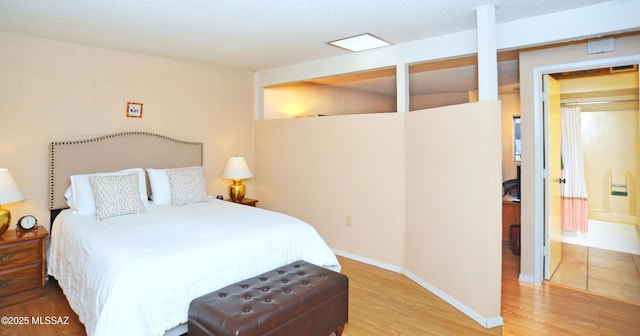 bedroom with a textured ceiling and wood-type flooring