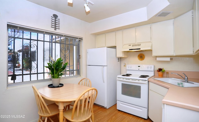 kitchen with sink, white cabinets, a wealth of natural light, white appliances, and light hardwood / wood-style floors