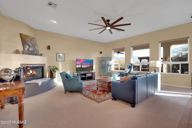 living area featuring visible vents, baseboards, a multi sided fireplace, and ceiling fan