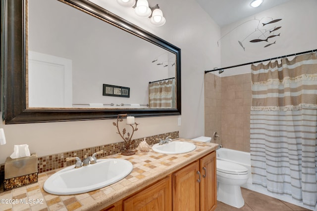 full bath with tile patterned floors, shower / bath combination with curtain, a sink, and toilet