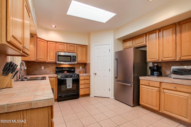 kitchen featuring tasteful backsplash, sink, tile counters, and stainless steel appliances