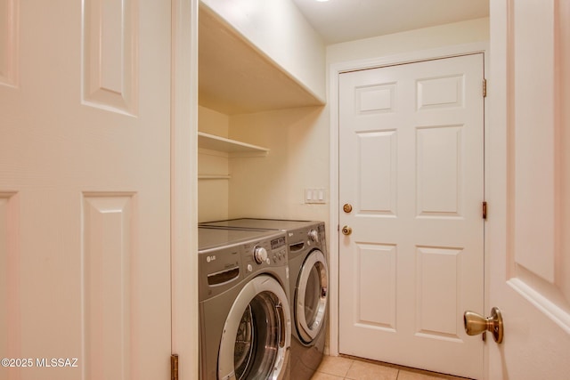 laundry area with light tile patterned floors and washer and clothes dryer