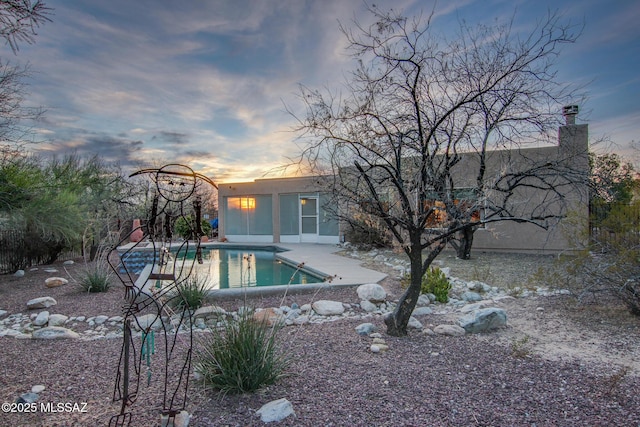 pool at dusk with a patio