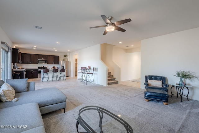 living room featuring ceiling fan and light colored carpet