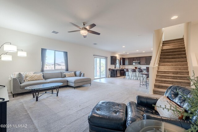 living room featuring light colored carpet and ceiling fan