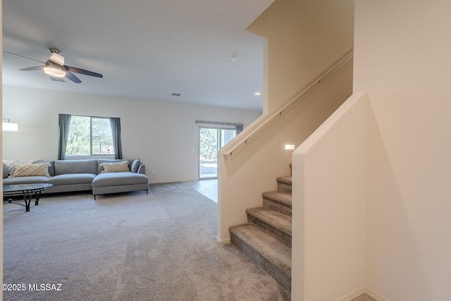 carpeted living room featuring ceiling fan and a wealth of natural light