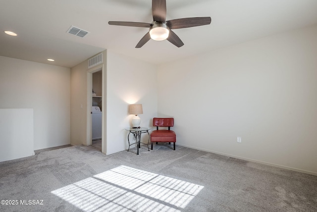 unfurnished room featuring ceiling fan, light colored carpet, and washer / clothes dryer