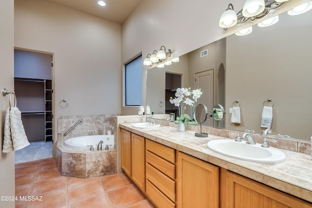 bathroom featuring tiled tub, tile patterned floors, and vanity